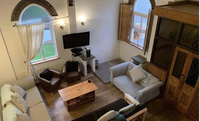 Spacious Lounge with vaulted ceiling, exposing beams and original roof ties of the chapel. All ground floor doors are widened and have wheelchair acce